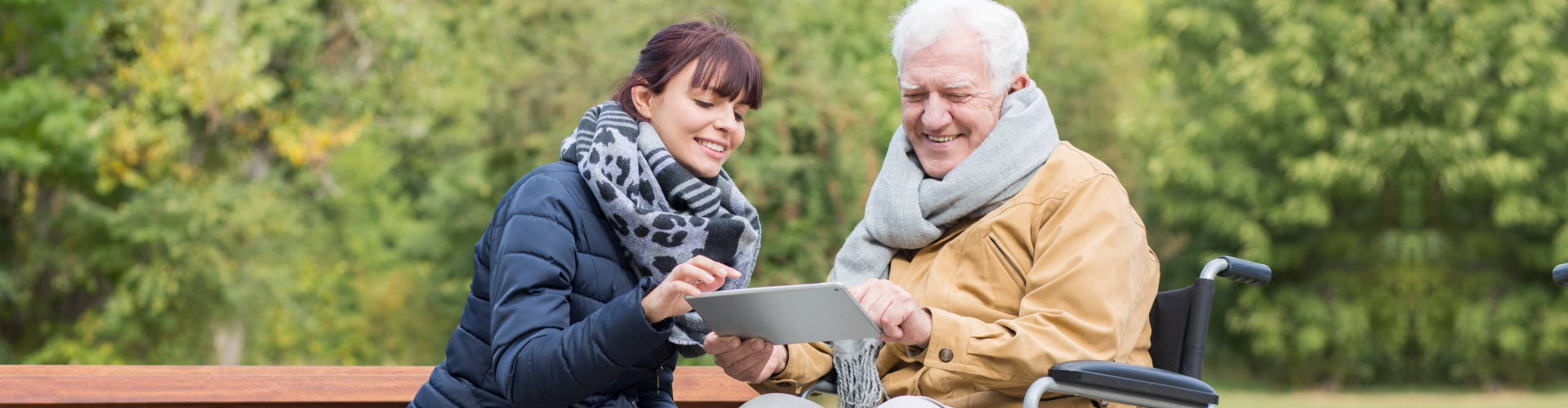 woman and senior man looking at the tablet