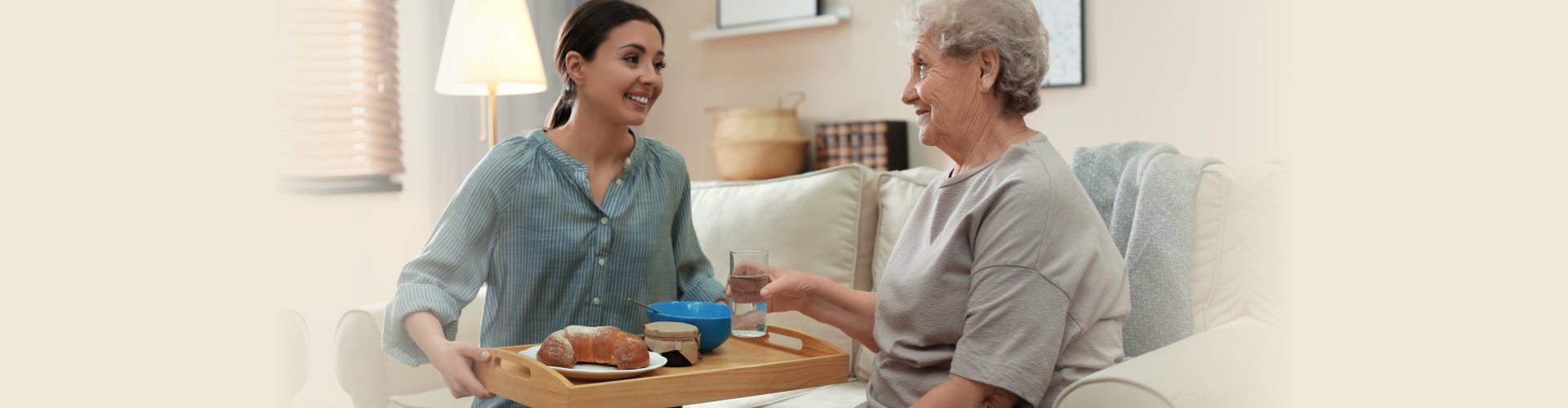 woman bringing food for the senior woman