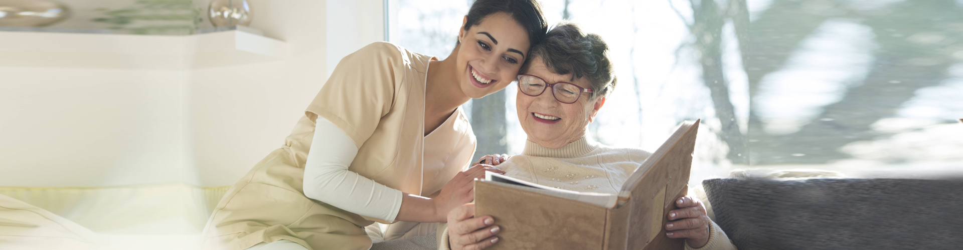 caregiver and senior woman reading a book